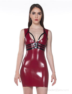 A brunette woman wearing a plum latex dress and a black Latex Halter Cage by Syren Latex poses in front of a blank background. The cage has a silver zipper in the center of the band.