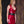 Load image into Gallery viewer, A blonde woman stands against a decorated wall. She wears the Little V Latex Dress from Syren Latex in red as well as a black PVC waist cincher. The dress has tanktop sleeves and a deep V-neck. The hem cuts off at her mid-thigh.
